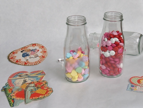 quick cheap valentine candy holder, crafts, repurposing upcycling, seasonal holiday decor, valentines day ideas, This is how they will look with candy in them hearts do not show up too well but you can buy big bags of candy which is cheaper and pour the candy in the bottles