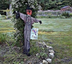 scarecrow love, outdoor living, seasonal holiday decor, Scarecrow in the bird feeding bed with the autumn climatis in bloom