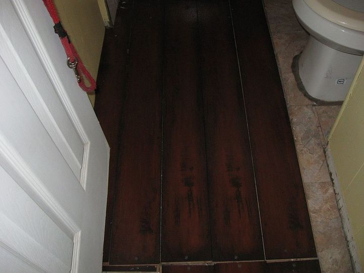 q single wide mobile home with really small bathroom no clue for floor, bathroom ideas, flooring, home decor, home maintenance repairs, small bathroom ideas, this is the current flooring in our bathroom mixture of wood laminate and vinyl flooring