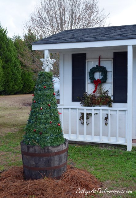 a country cottage decorated for christmas, curb appeal, seasonal holiday decor, outdoor tree in a barrel