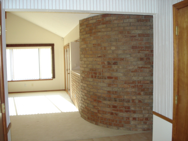 help can you help redo this living room rock brick bookshelf off center window, Right side of living room shows same window curved brick wall and planter