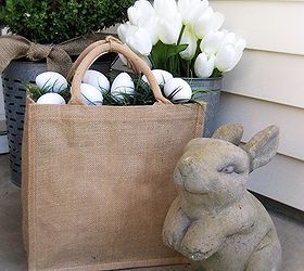 a farmhouse porch for spring, porches, seasonal holiday decor, windows, wreaths, A stone bunny and a burlap bag filled with eggs are on the opposite side of the porch