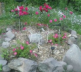 whimsical garden ideas, gardening, This is our small rose garden The three trees in the center fiber optic and change colors The rocks are dusted in glitter but it does not show in this photo