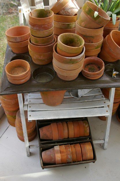 re using industrial bread pans, gardening, repurposing upcycling, An industrial metal bread pan and a muffin top pan hold terra cotta flowerpots in my Garden House Makeover Project