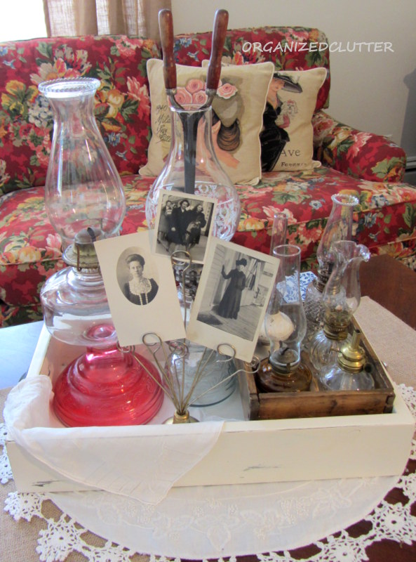 decorating with collections oil lamps, home decor, Photographs of vintage aunts and a old curling iron complete the display