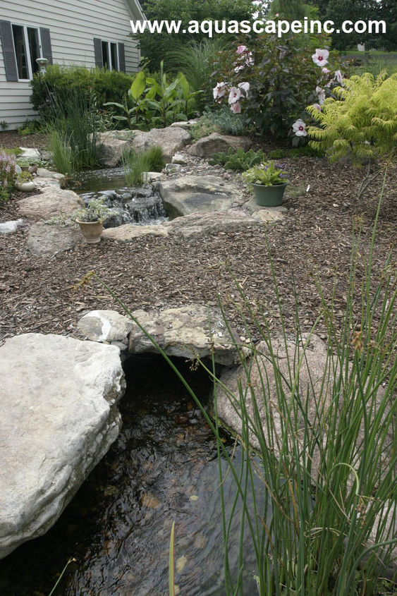 refresh your landscape with water, gardening, outdoor living, ponds water features, A simple land bridge was added over the stream providing a way to explore and enjoy the pond from all sides Be sure to incorporate interactive areas into your pond where you can dangle your feet or feed the fish