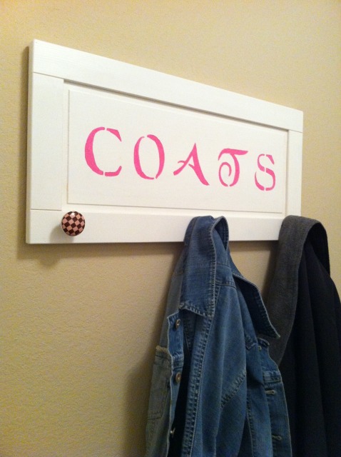 laundry room before amp after, decks, laundry rooms, On the wall opposite the washer and dryer I used another of the cabinet doors to hang our jackets on when we come home The cute checkered knobs were a clearance find at Hobby Lobby for 1 02 each Perfect Instead of wooden letters I stenciled the letters on using a nice bright pink