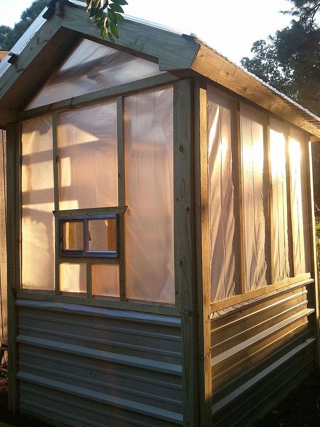 greenhouse built for less than 700, diy, gardening, outdoor living, Backside view the little window is new material Right now it has 2 layers of heavy plastic above the metal siding When that wears out we ll replace with the same thing we used on the roof Sun tuf panels bought at Lowe s